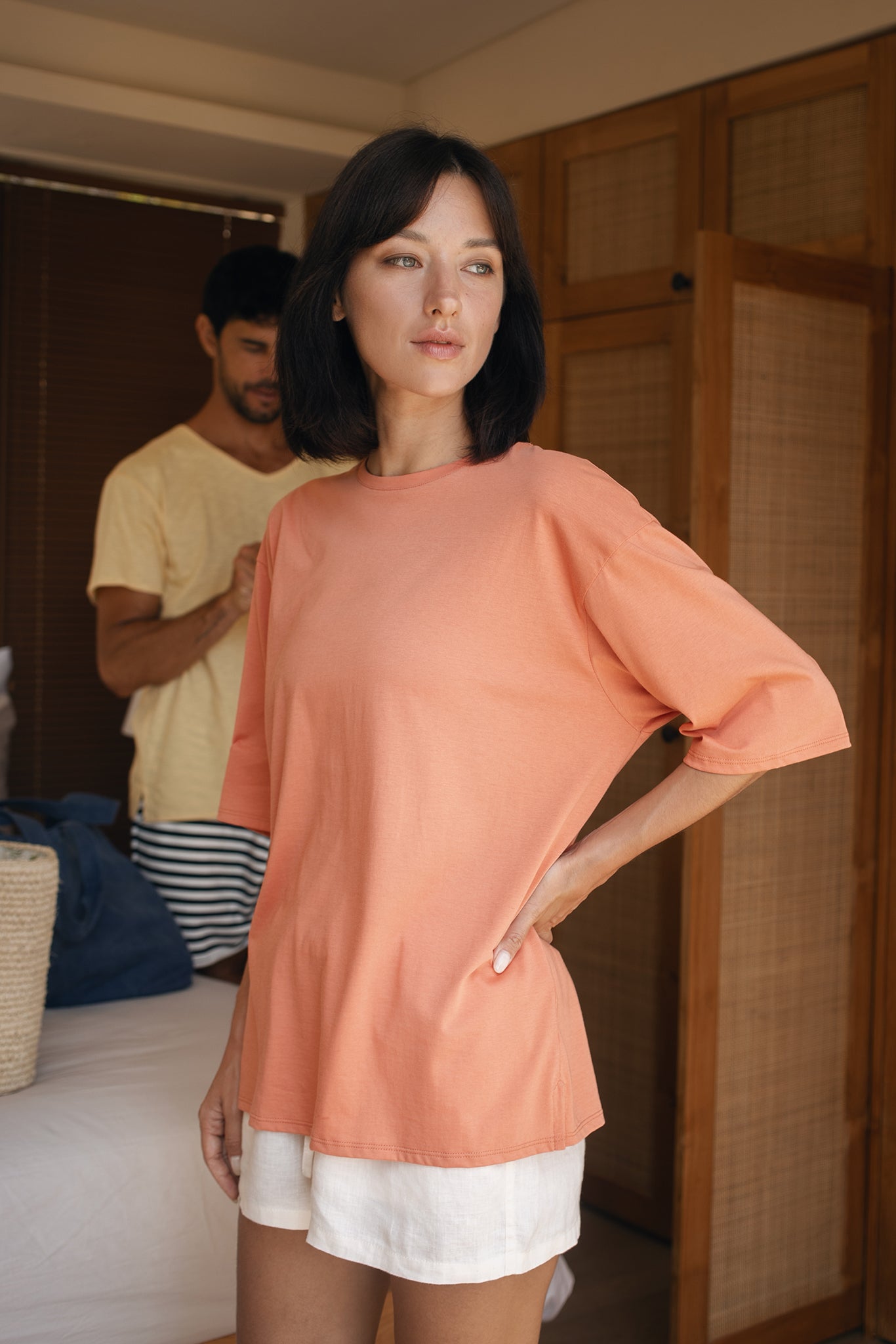 Woman in a peach-colored cotton top T-shirt standing in a resort in Bali