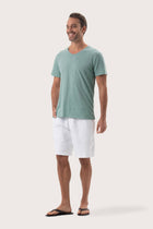 Side profile of the Aling T-Shirt Sage by By The Sea Bali – relaxed drape and understated island elegance