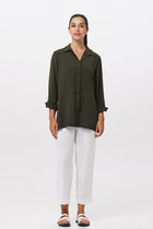 Woman wearing the Amalia Side Slit Shirt Army Green designed for effortless resortwear and tropical living by By The Sea Bali.