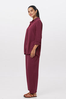 Side profile of the Amalia Side Slit Shirt Brick with matching color pants showing its cut and natural movement.