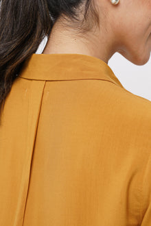 Close up detail of the Amalia Side Slit Shirt Mustard highlighting craftsmanship and design features.