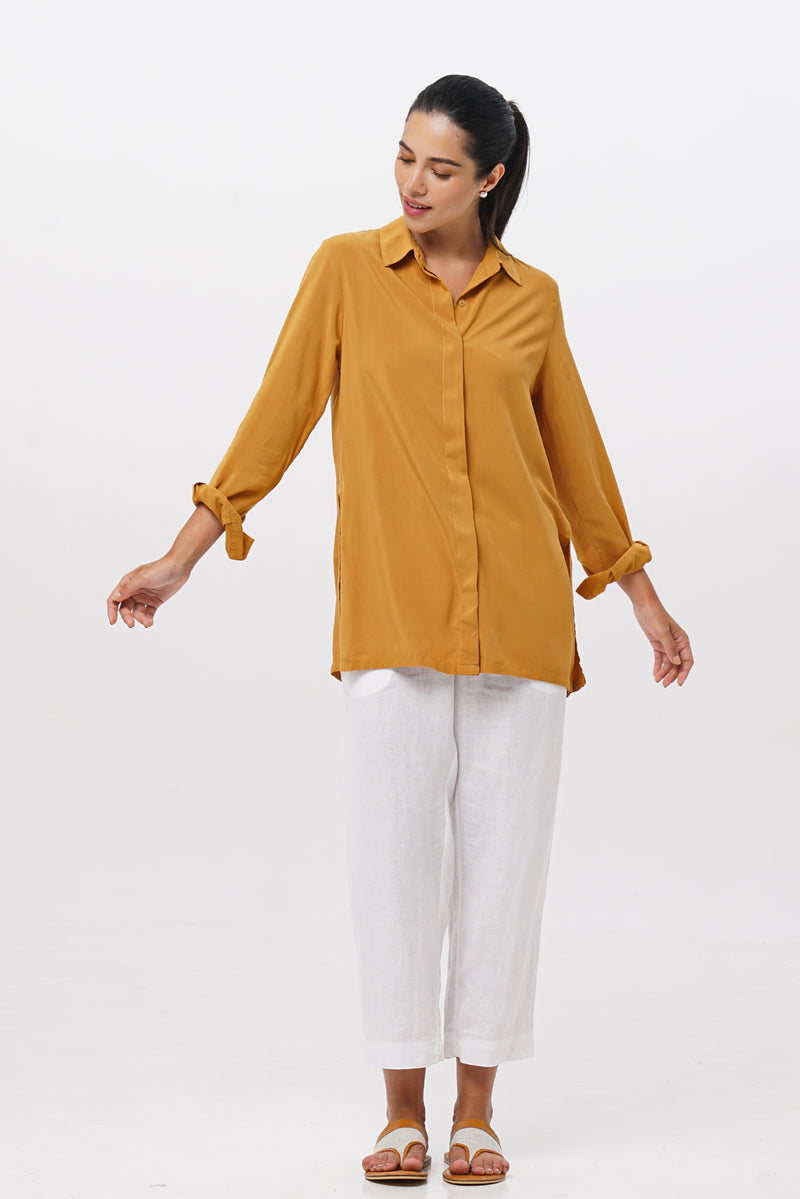 Woman wearing the Amalia Side Slit Shirt Mustard designed for effortless resortwear and tropical living by By The Sea Bali.