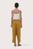 Back view of the mustard linen pants with a relaxed and elegant silhouette