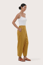 Side profile of the mustard linen pants showcasing their comfortable fit and effortless drape