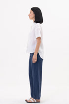 Side profile of the Anse Short Sleeve Linen Blouse White showcasing its relaxed fit and fluid drape