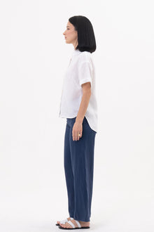 Side profile of the Anse Short Sleeve Linen Blouse White showcasing its relaxed fit and fluid drape