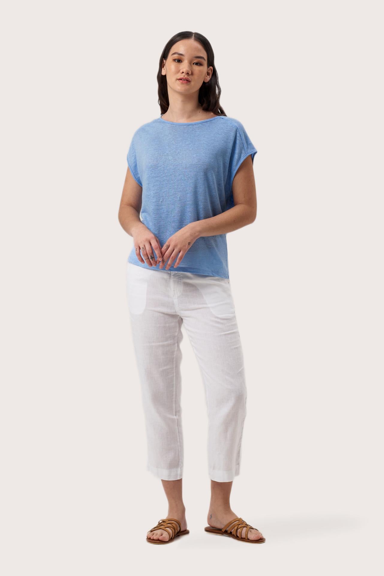 Woman wearing the Aria Linen T-Shirt Bleue Clair designed for effortless resortwear and tropical living by By The Sea Bali.
