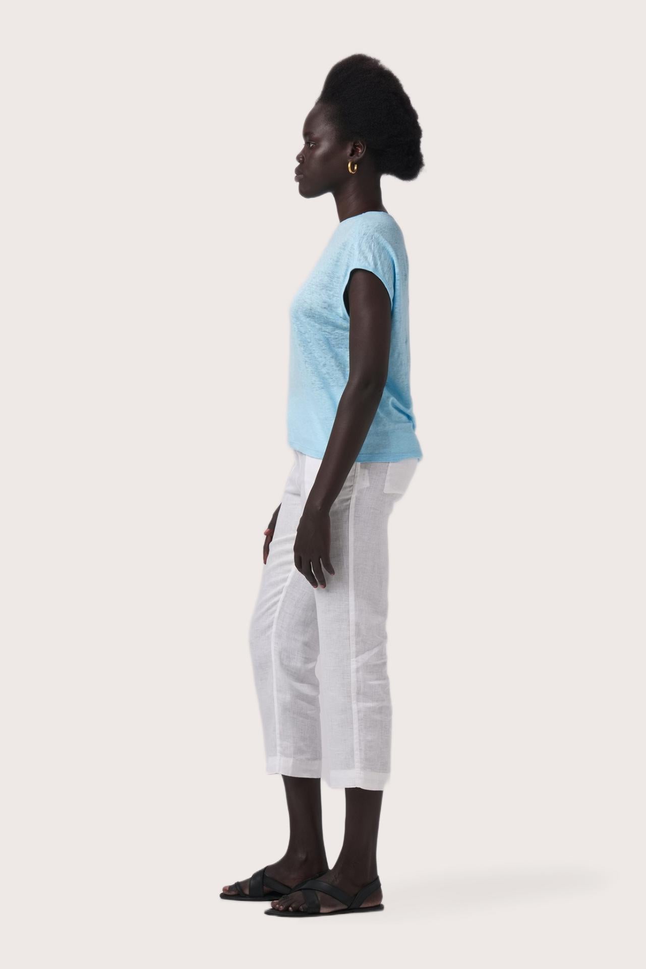 Side profile of the Aria Linen T-Shirt Cielo showing its cut and natural movement.