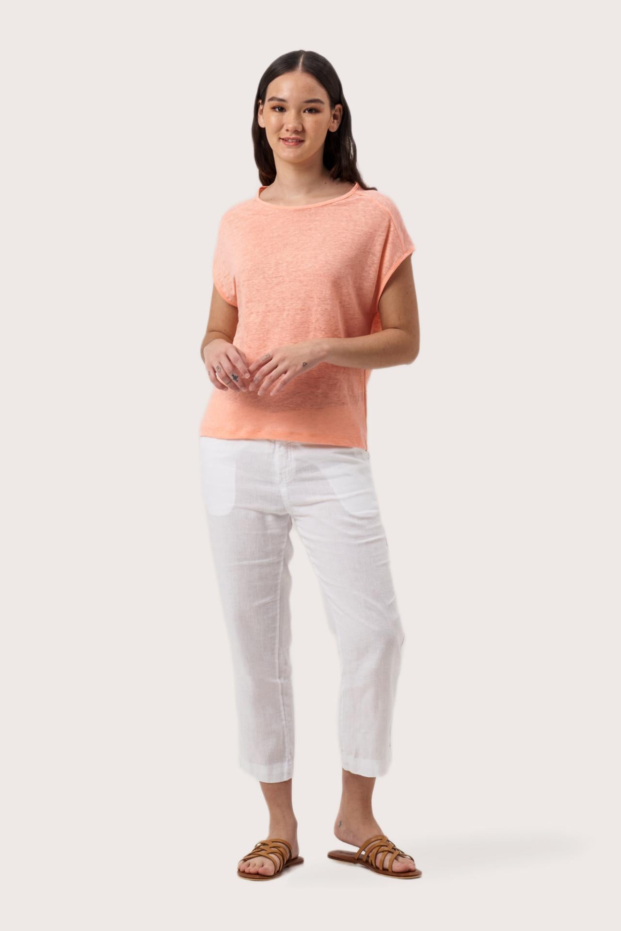Woman wearing the Aria Linen T-Shirt Peach designed for effortless resortwear and tropical living by By The Sea Bali.
