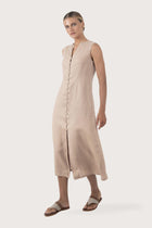 Side profile of the Ayu Linen Maxi Dress Nude showing its cut and natural movement