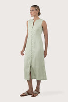 Side profile of the Ayu Linen Maxi Dress Pastel Green showing its cut and natural movement