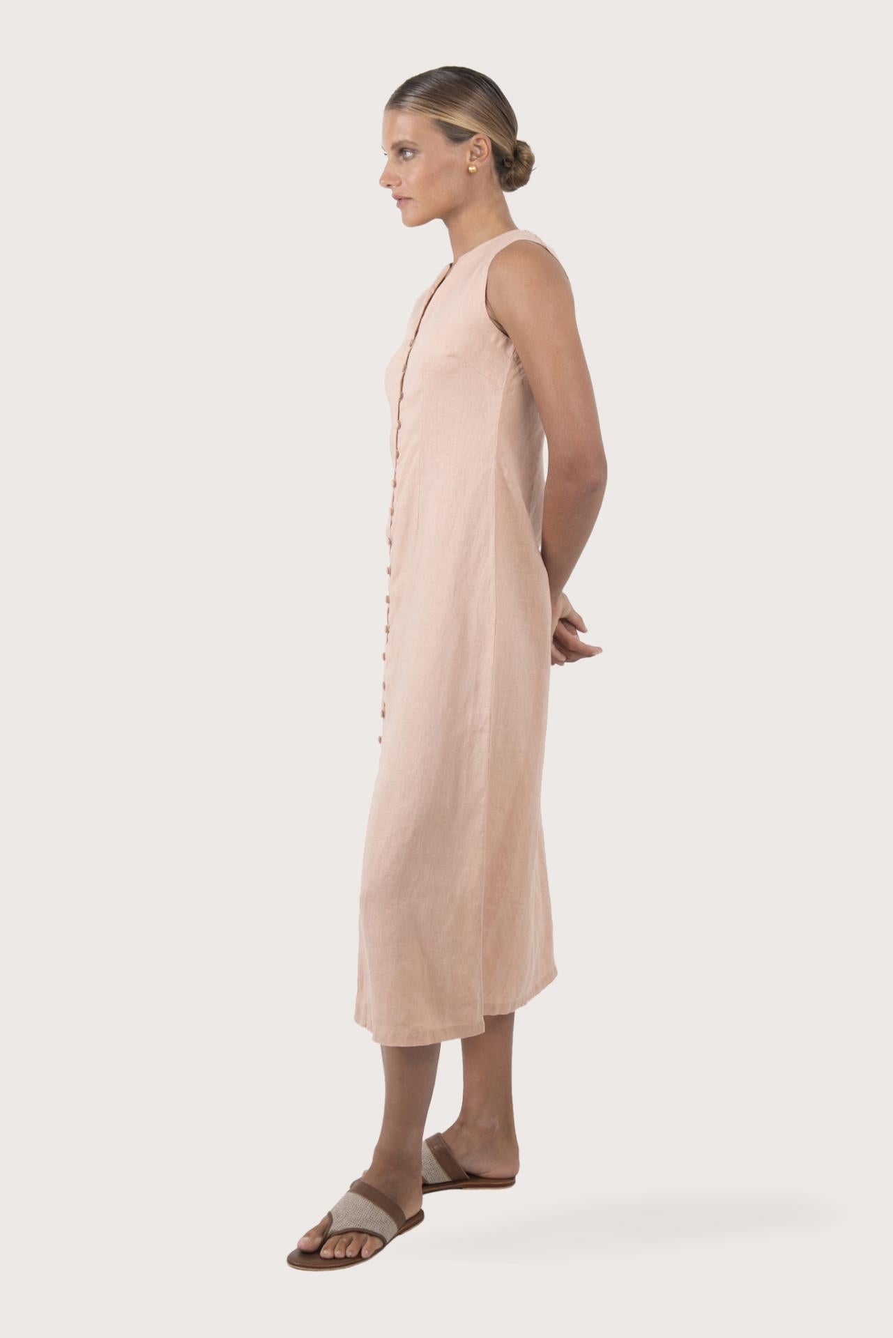 Side profile of the Ayu Linen Maxi Dress Pastel Pink showing its cut and natural movement