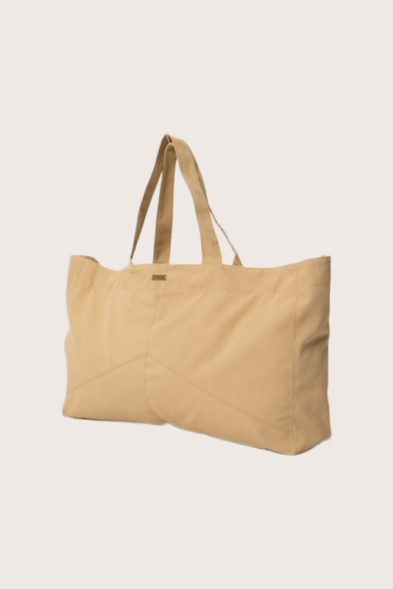 Angled view of the creme Barcha tote bag showcasing its spacious design