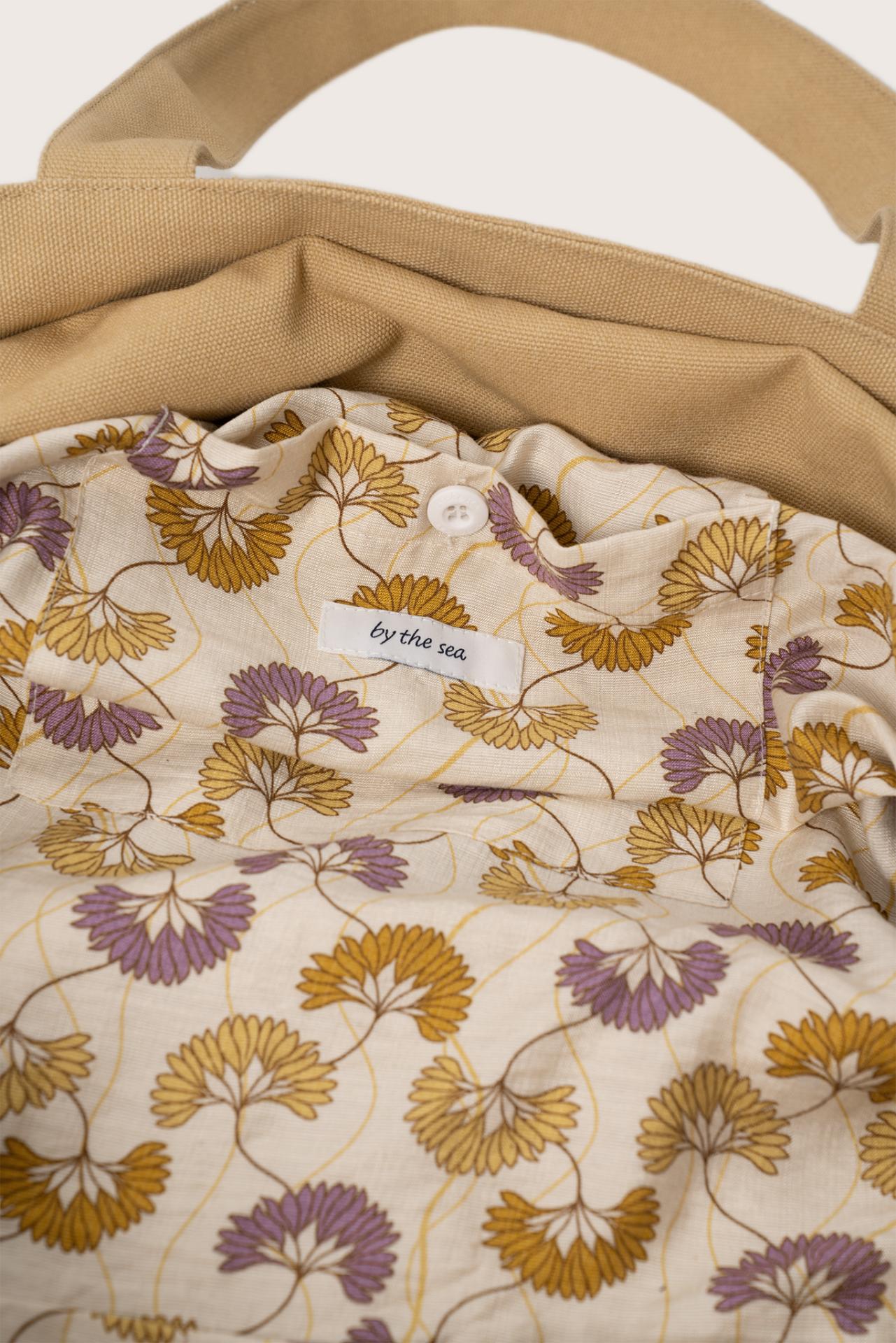 Close-up of the interior lining and stitching details of the creme Barcha tote bag