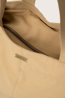 Close-up of the zipper and polyester cotton fabric on the creme Barcha tote bag