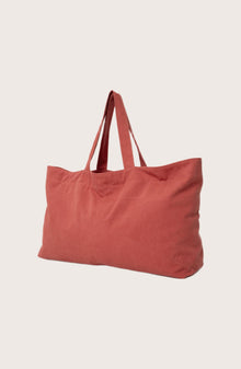 Angled view of the red Barcha tote bag showcasing its spacious design