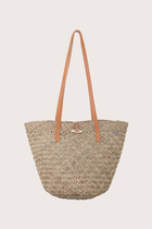 Beach bucket straw bag in natural woven finish styled as an elevated resort accessory, front view