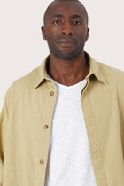 Close-up of the fabric texture and refined jacket detailing in light yellow