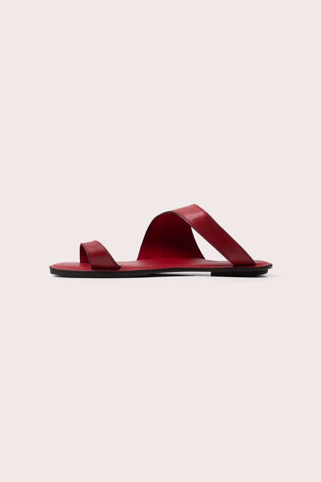 Side profile of Bitsy sandal in red highlighting sleek resort footwear silhouette