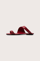 Side profile of Bitsy sandal in red highlighting sleek resort footwear silhouette