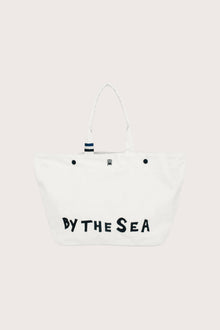 By The Sea beach bag in refined woven finish styled as an elevated resort essential, front view