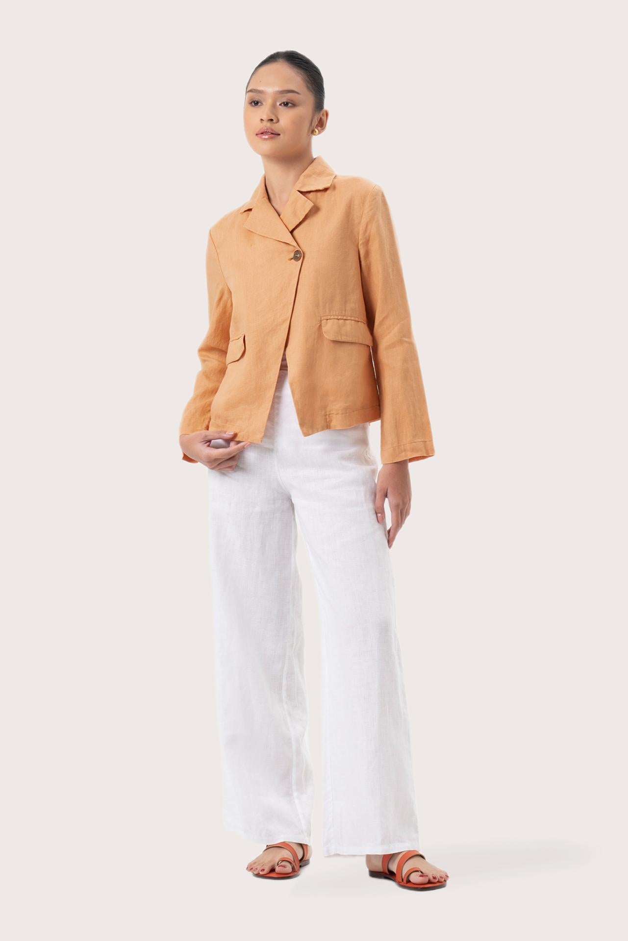 Woman wearing the Cala Linen Blazer Orange designed for effortless resortwear and tropical living by By The Sea Bali