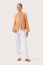 Woman wearing the Cala Linen Blazer Orange designed for effortless resortwear and tropical living by By The Sea Bali