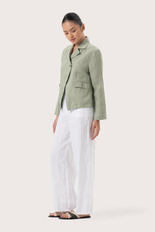Side profile of the Cala Linen Blazer Sage showing its cut and natural movement