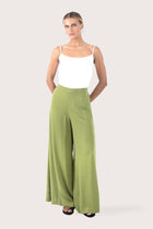 Woman wearing the Callie Palazzo Pants Green designed for effortless resortwear and tropical living, by By The Sea Bali