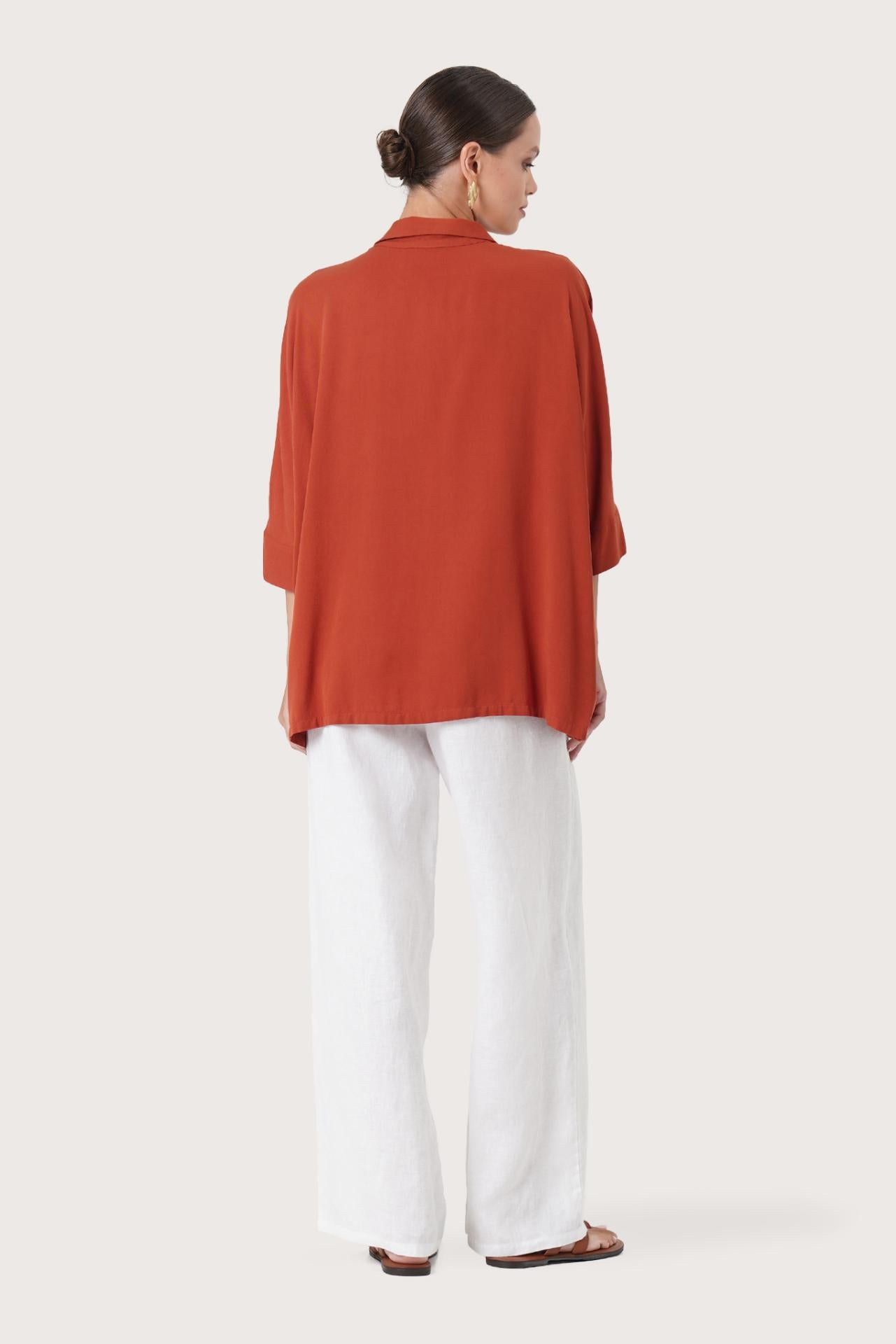 Back view of the Candidasa Shirt Red highlighting the garment shape and drape.