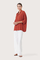 Side profile of the Candidasa Shirt Red showing its cut and natural movement.