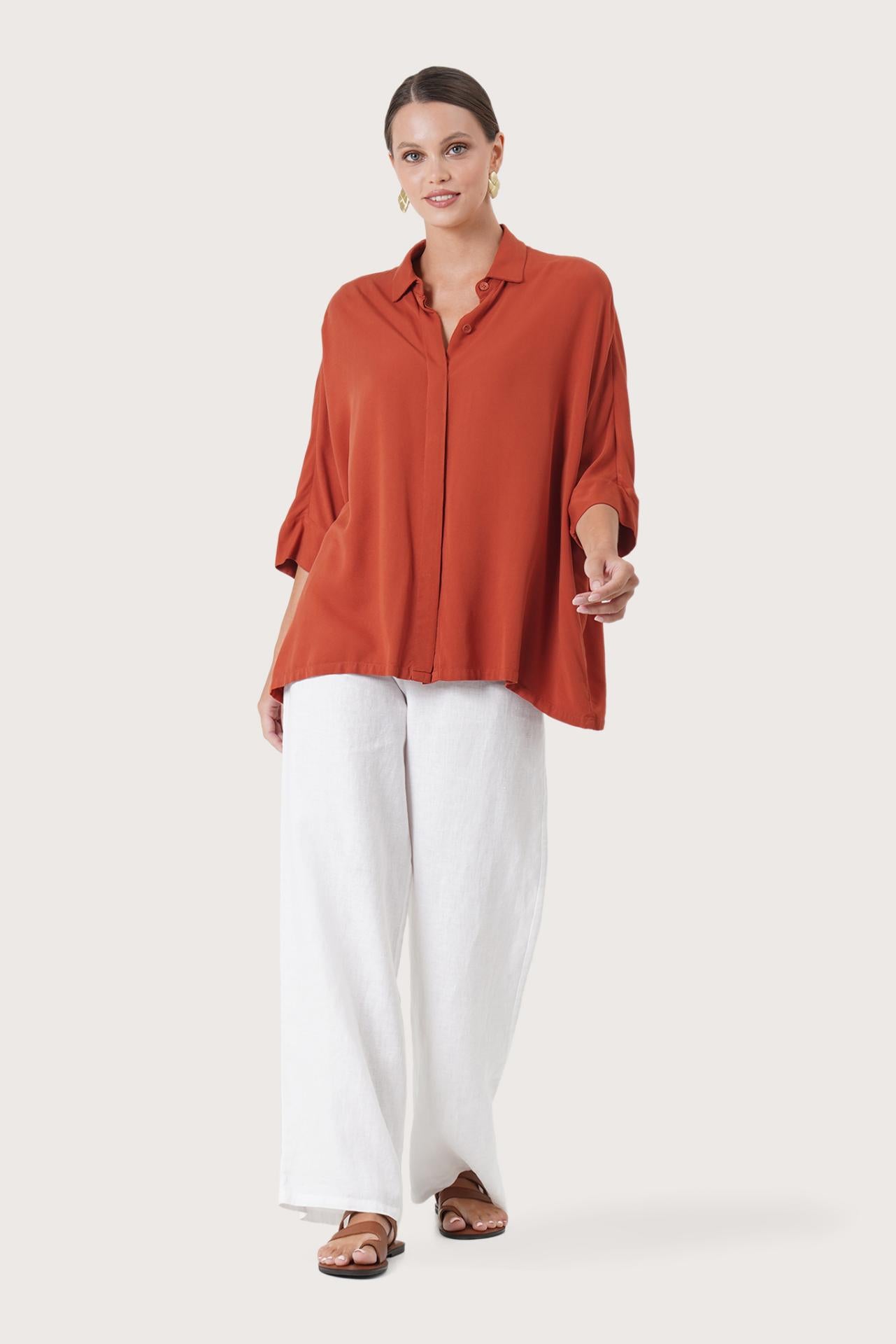 Woman wearing the Candidasa Shirt Red designed for effortless resortwear and tropical living by By The Sea Bali.