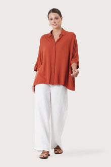 Woman wearing the Candidasa Shirt Red designed for effortless resortwear and tropical living by By The Sea Bali.