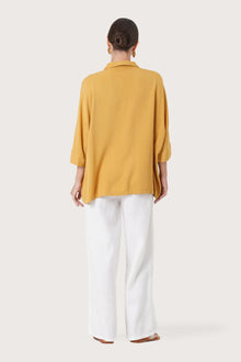 Back view of the Candidasa Shirt Yellow highlighting the garment shape and drape.