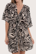 Close-up of the twisted front detail and paisley print on the black short kaftan