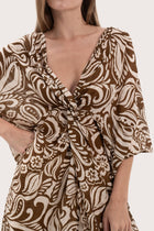 Close-up of the twisted front detail and paisley print on the brown short kaftan