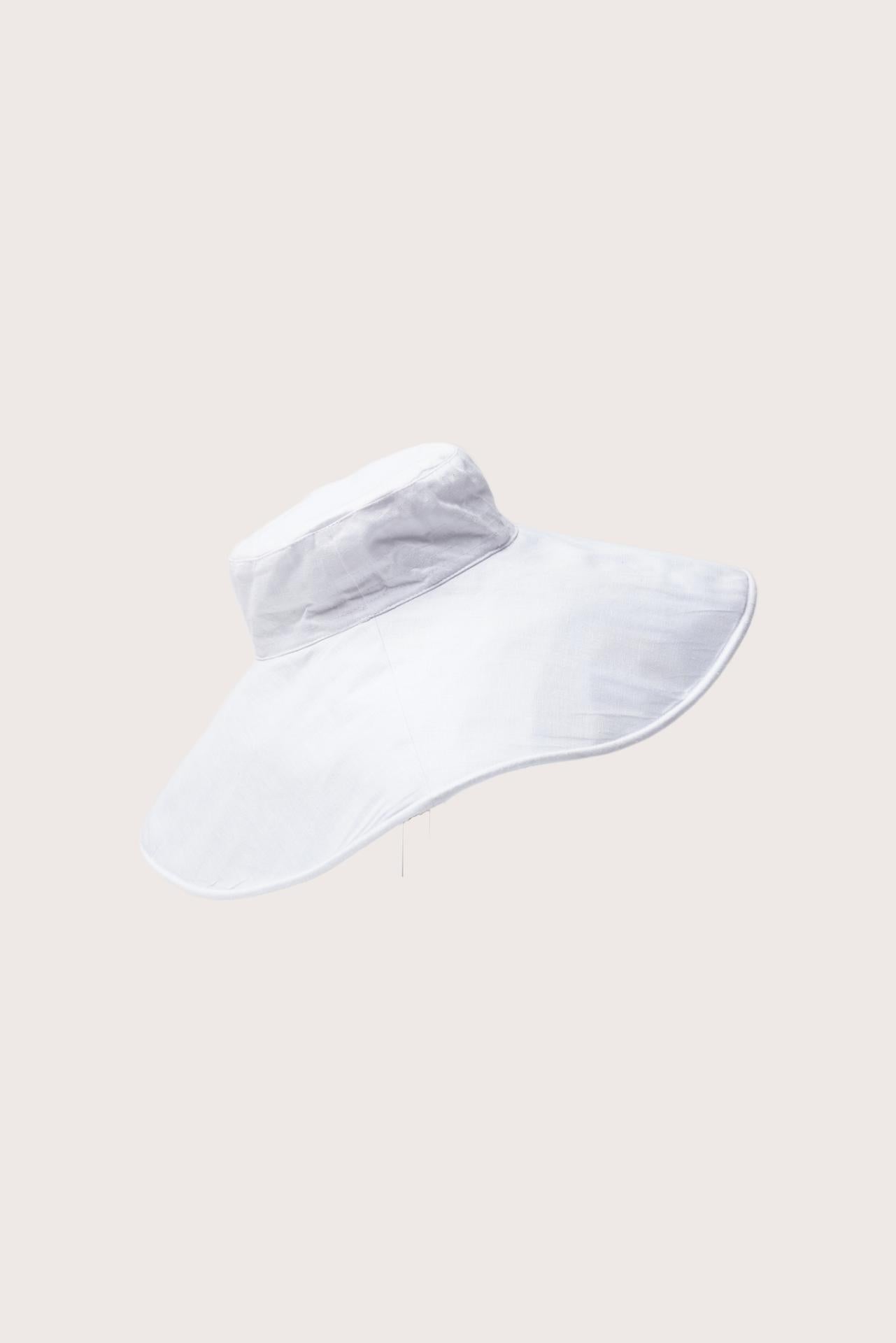Elegant angled view of the Capri Linen Hat emphasizing its fluid brim and minimalist design