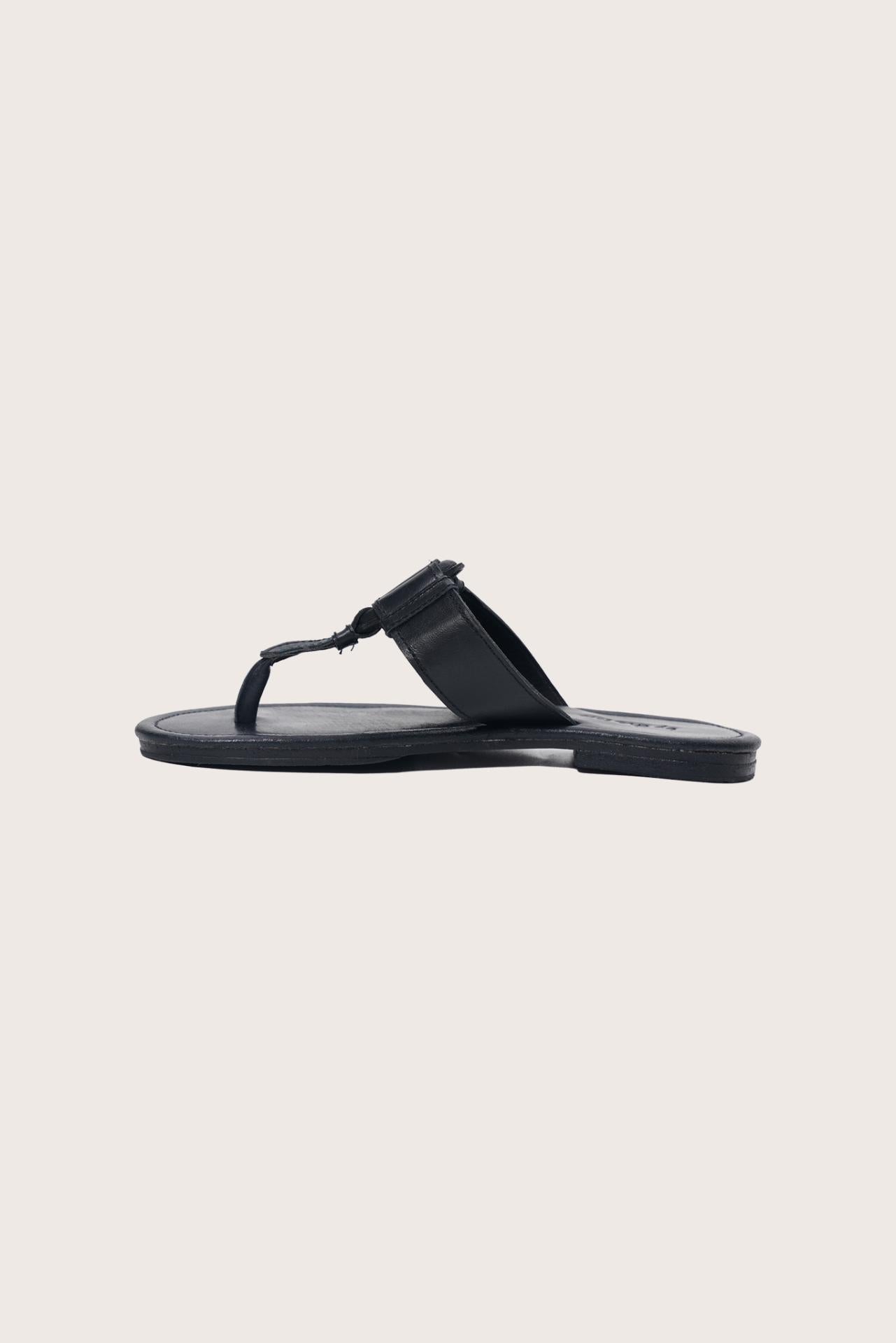 Side profile of the black leather Cate sandals highlighting the strap design