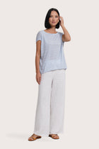 Front profile of woman wearing the Cyra T-shirt Stripe light blue designed for effortless resortwear and tropical living by By The Sea Bali.