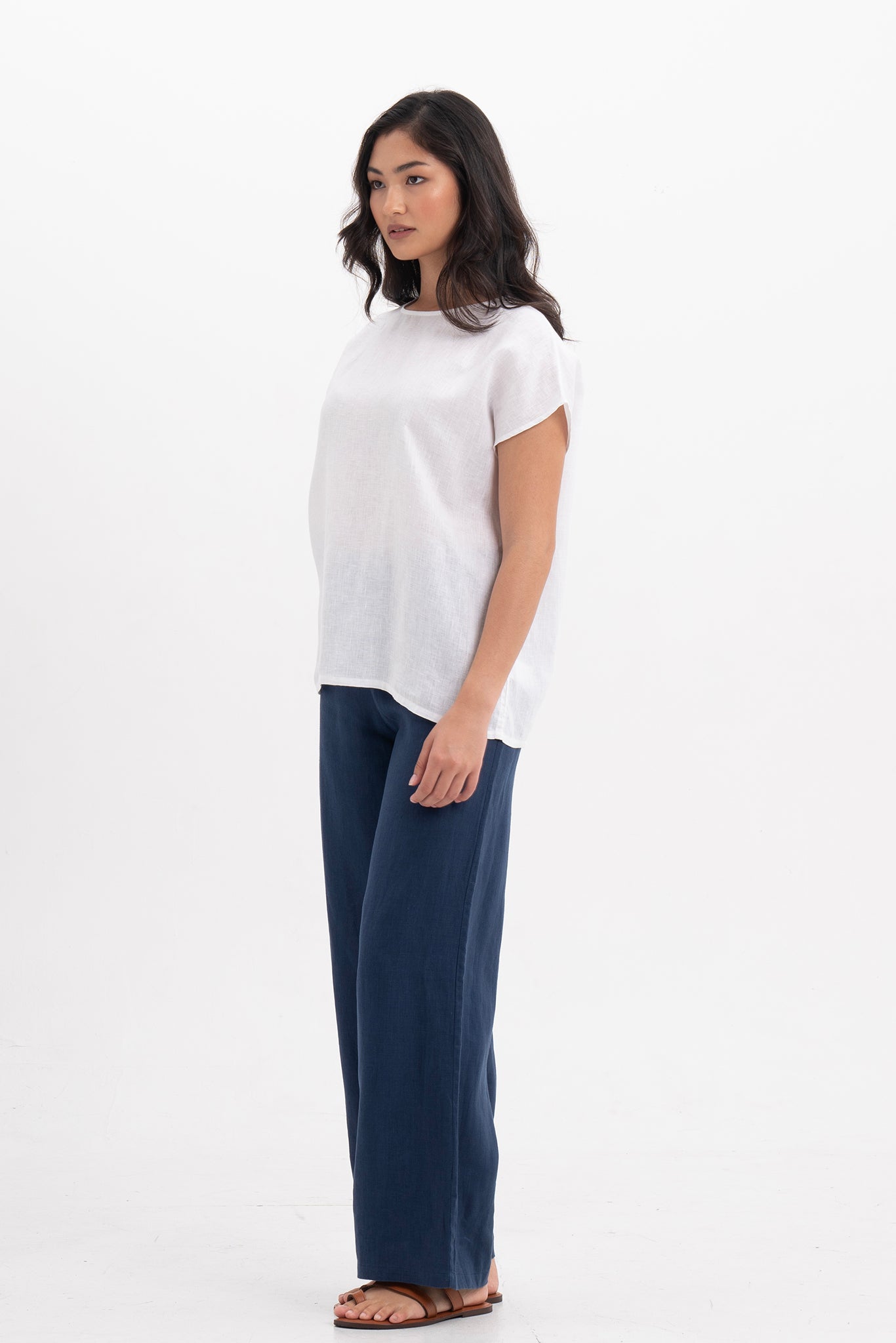 Side profile of the Darya Linen Top White showing its cut and natural movement.