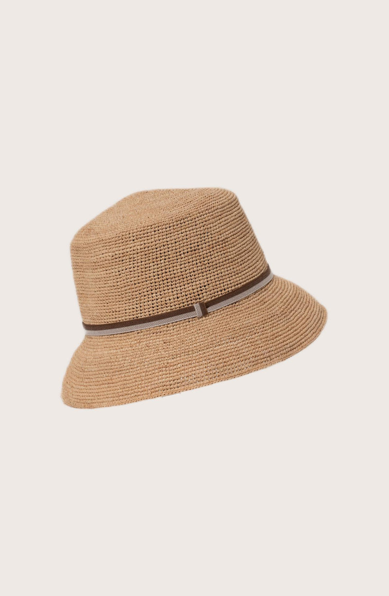 Model wearing the natural straw Dewy hat with a brown ribbon by By The Sea Bali