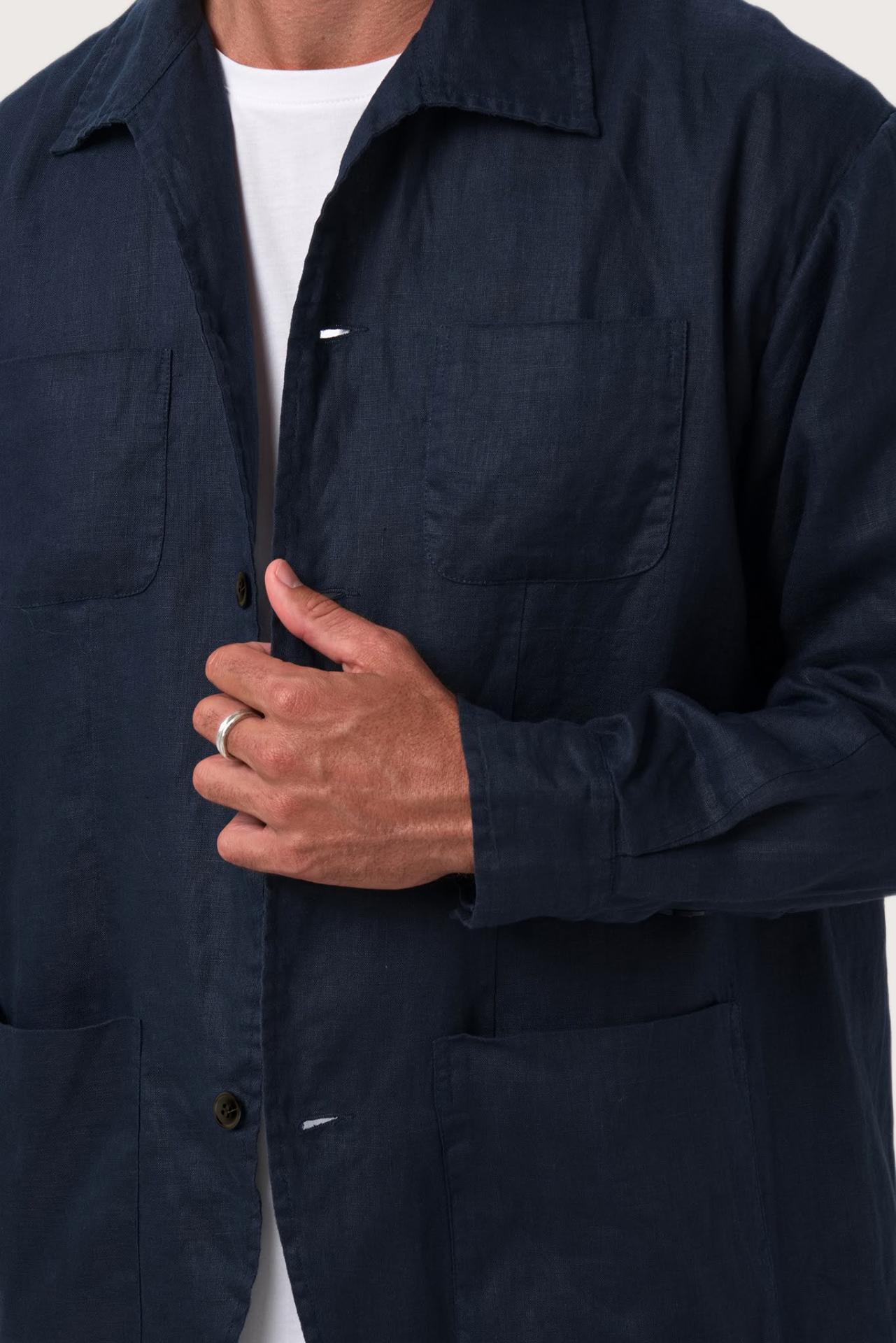 Close-up of the linen fabric texture and refined tailoring details on the navy jacket