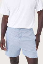 Close-up of the linen fabric texture and refined tailoring details on the blue shorts