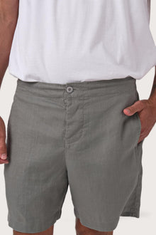 Close-up of the linen fabric texture and refined tailoring details on the grigio shorts