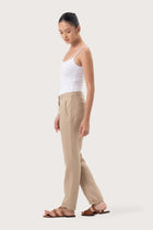 Side profile of the Hampton Women's Linen Pants Creme showing its cut and natural movement.