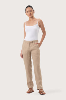Woman wearing the Hampton Women's Linen Pants Creme designed for effortless resortwear and tropical living by By The Sea Bali.