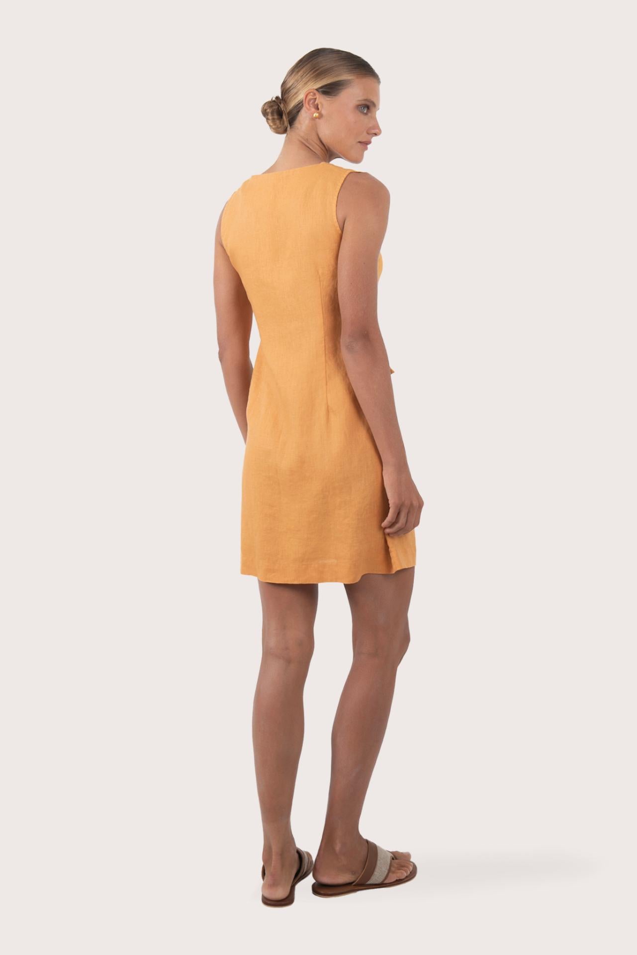 Back view of the Isla Linen Dress Orange highlighting the garment shape and drape