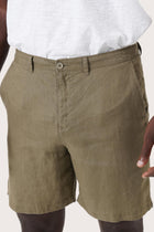 Close-up of the linen fabric texture and refined tailoring details on the brown bermuda shorts