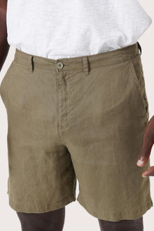 Close-up of the linen fabric texture and refined tailoring details on the brown bermuda shorts
