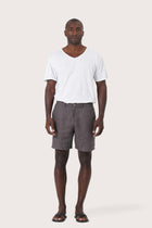 Model wearing the grey brown linen Kama bermuda shorts by By The Sea Bali